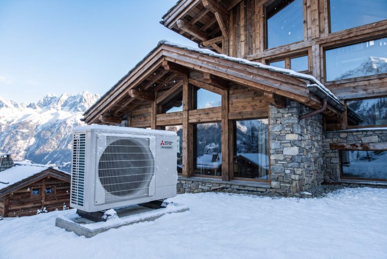Pompe à chaleur Mitsubishi Ecodan Zubadan devant une maison de montagne en hiver