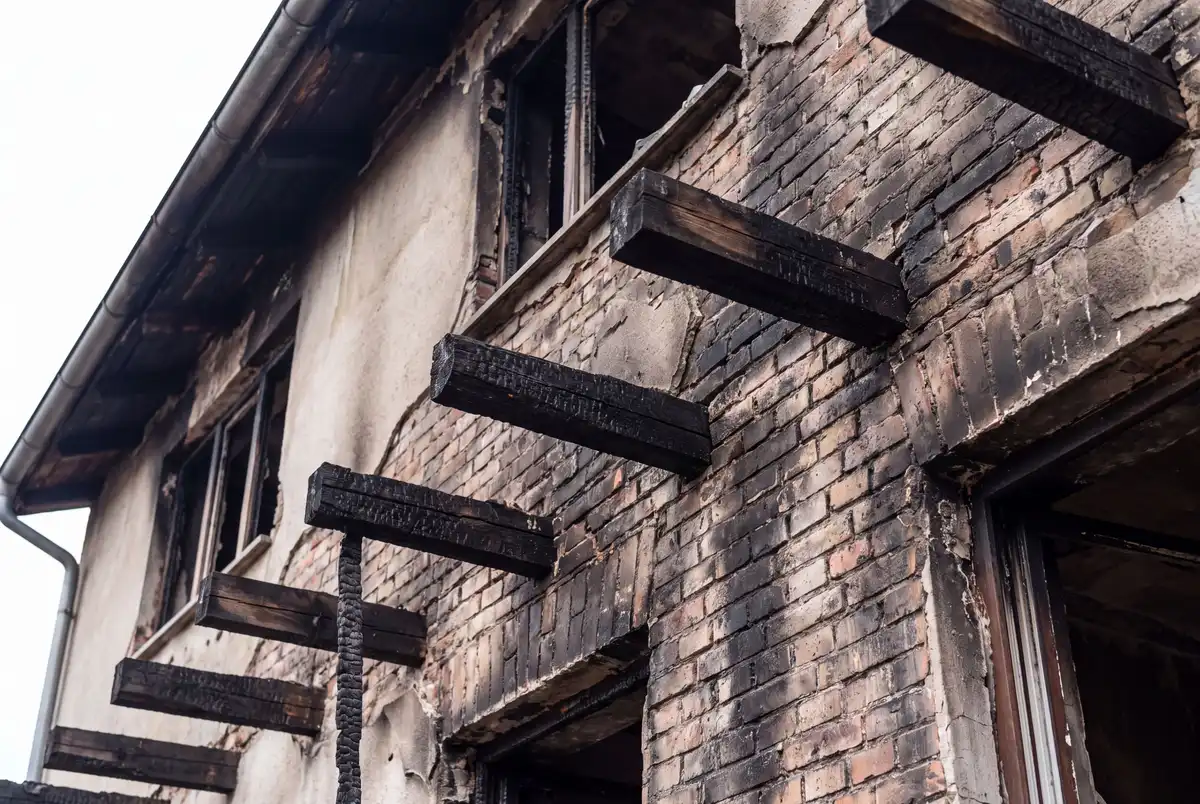 Dégâts d'incendie sur la structure d'une maison avec bois carbonisé et suie