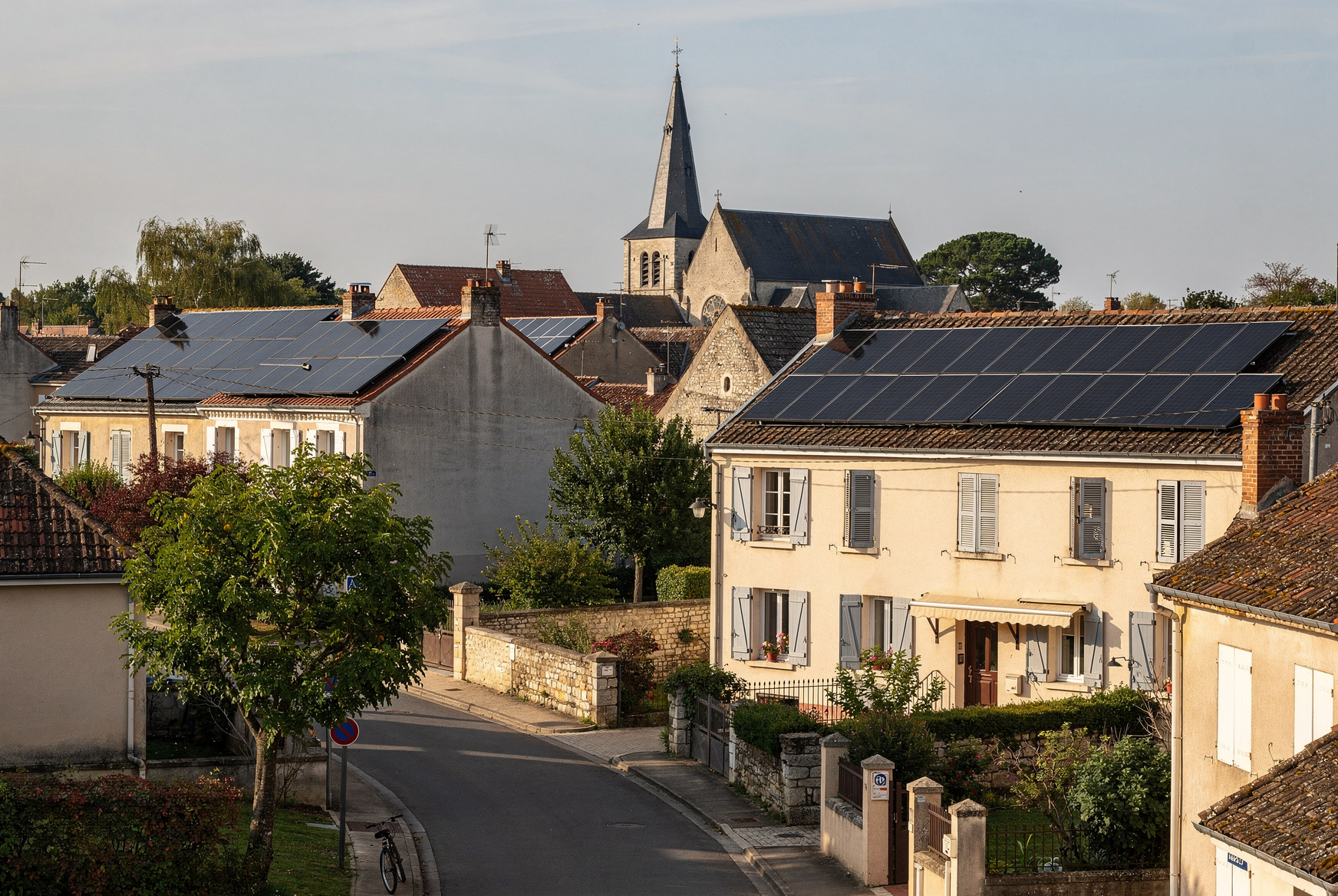 Quartier résidentiel vu d'en haut avec des panneaux solaires installés sur les toitures de plusieurs maisons voisines